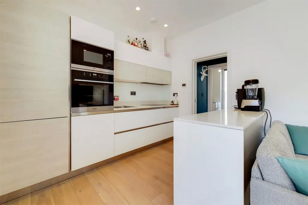 Kitchen island and living area with sofa and coffee machine